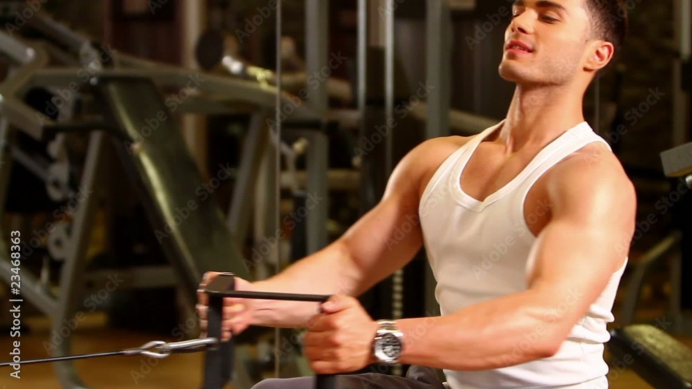 Handsome sporty man is exercising in gym centre Handsome sporty man is exercising in gym centre