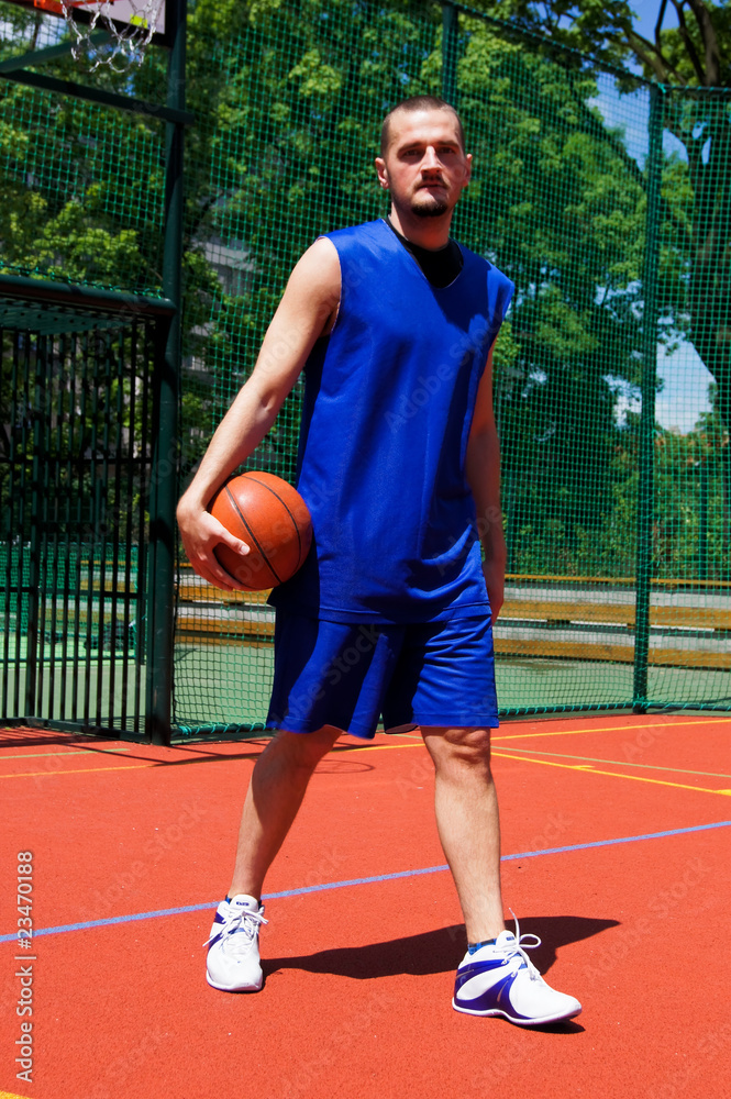 Young basketball player with ball on the sportground