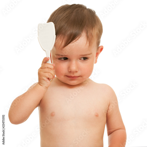 Toddler brushing his hair