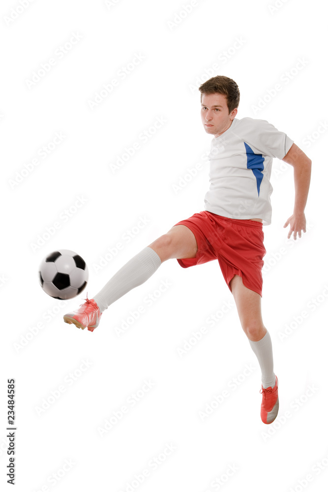 Soccer player kicking the ball isolated on white