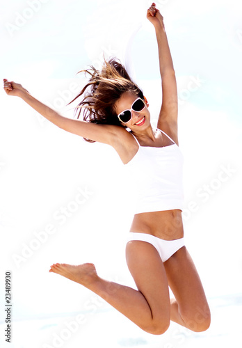 Young woman jumping on the beach