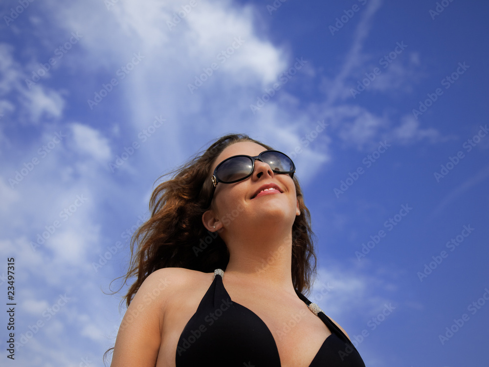 Beautiful girl with sunglasses in front of blue sky Beautiful girl with sunglasses in front of blue sky