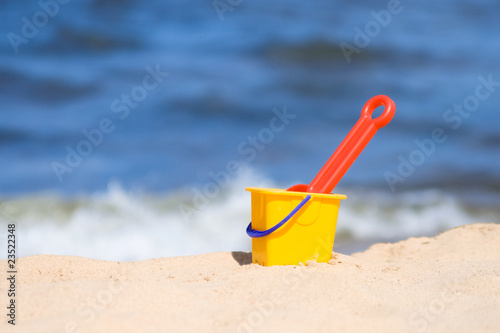 child's beach bucket and shovel on seacoast