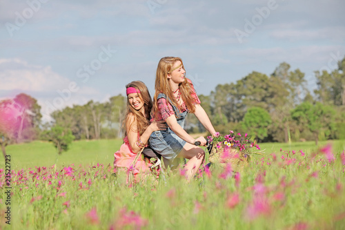 happy girls on bicycle in summer