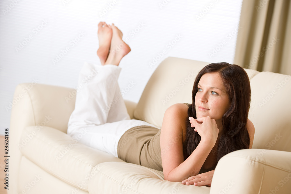 Young happy woman relax lying down on sofa Young happy woman relax lying down on sofa