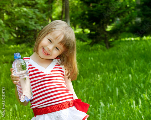 little girl with plastic bottle of mineral water