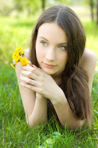 young beautiful teenager with dandelion on lawn