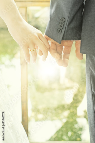 Closeup of bride and groom hands with selective focus © liubomirt