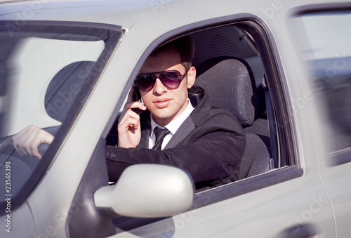 young businessman in his car  talking on a mobile phone © originalpunkt