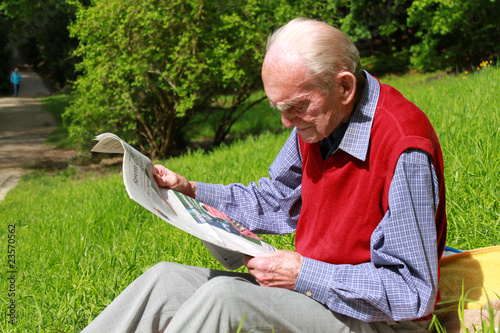Rüstiger Rentner beim Zeitung lesen in grüner Natur