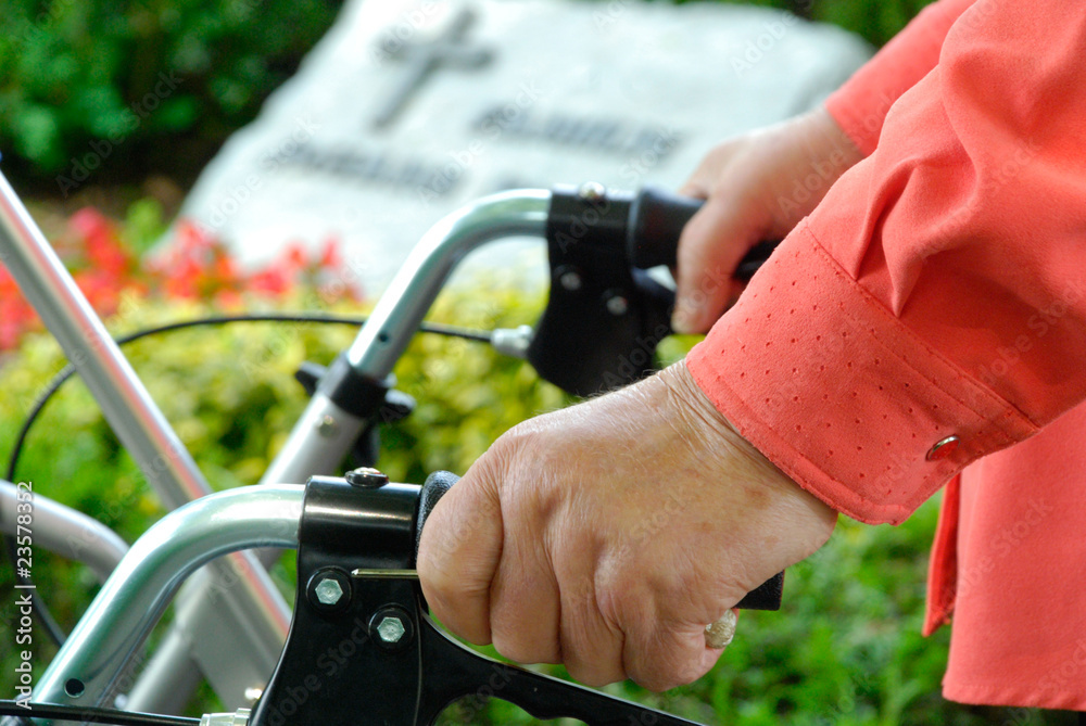 Hand einer alten Dame mit Rollator auf dem Friedhof Hand einer alten Dame mit Rollator auf dem Friedhof