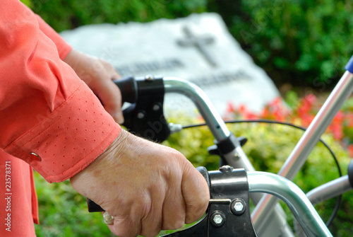 Hand einer alten Dame mit Rollator auf dem Friedhof