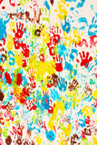 Handprints in different colors in a mural.
