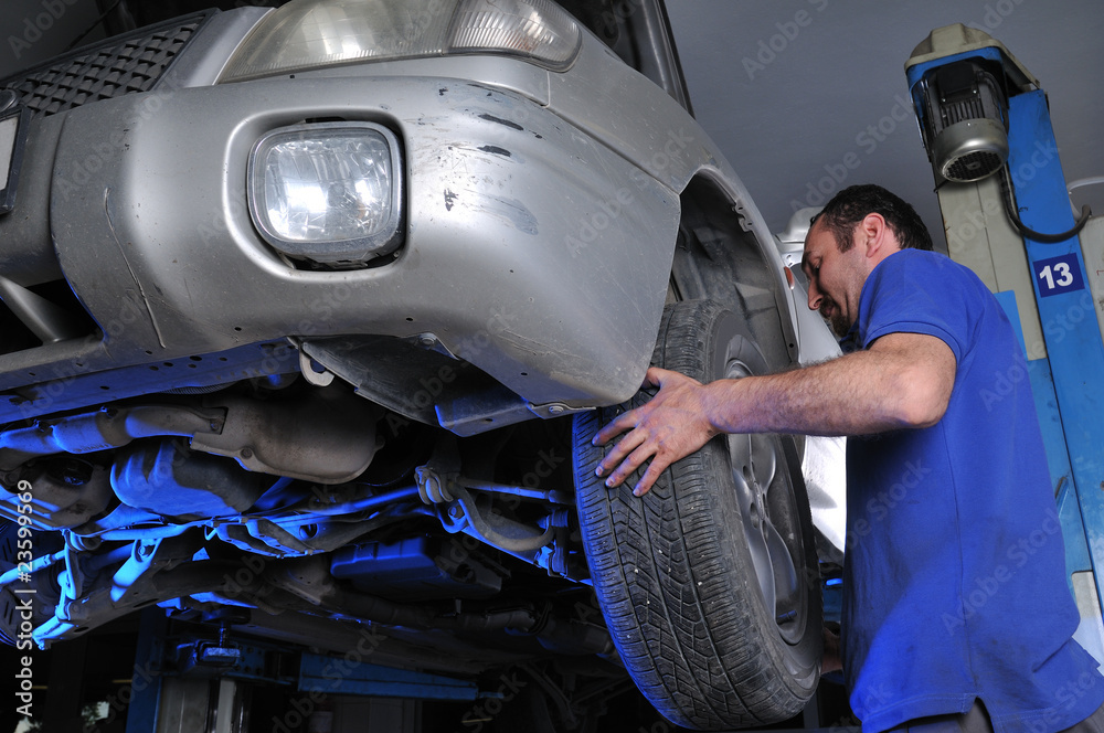 Car mechanic removing wheel nuts - a series of MECHANIC