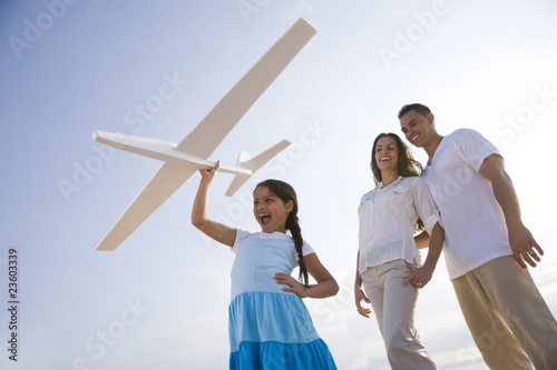 Hispanic family and girl having fun with toy plane