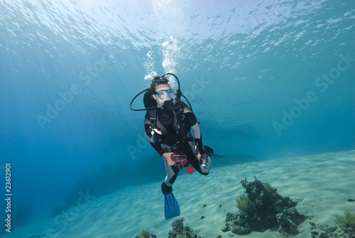 Young female scuba diver in clear blue water.