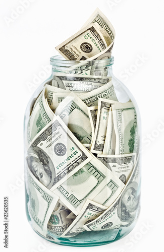 Many 100 US dollars bank notes in a glass jar