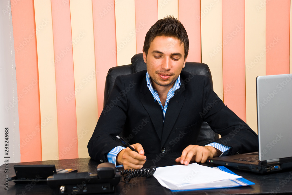 Happy business man write on paper in office Happy business man write on paper in office