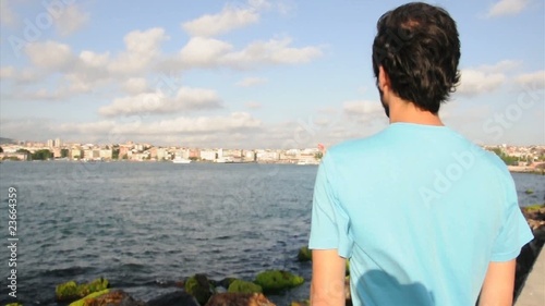 man with blue t shirt waiting by sea side photo