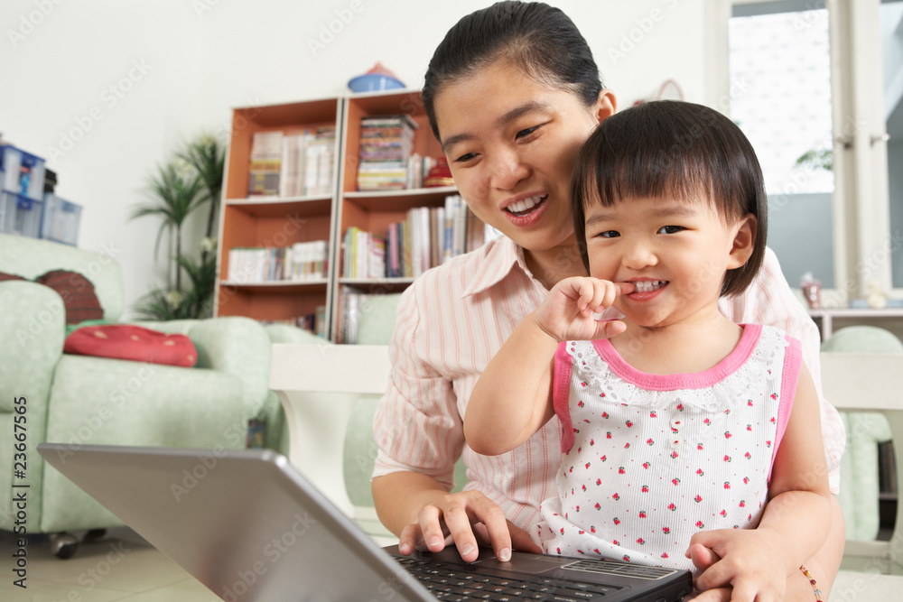 Mother and daughter playing laptop together Mother and daughter playing laptop together