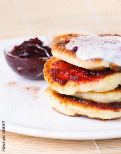 Fritters of cottage cheese with jam and sour cream