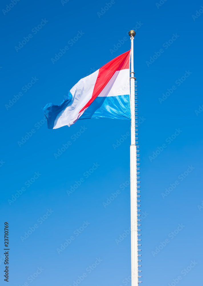 Flag of Luxembourg over blue sky