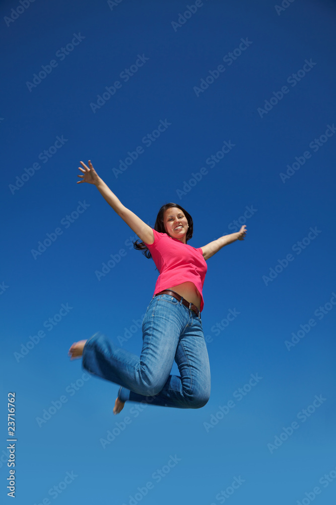 Asiatin springt vor blauem Himmel