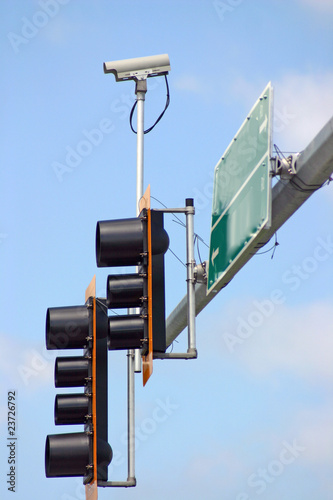 Security camera with traffic light and sign.