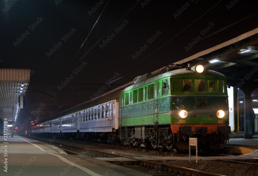 Fototapeta premium Passenger train waiting at the station platform during the night