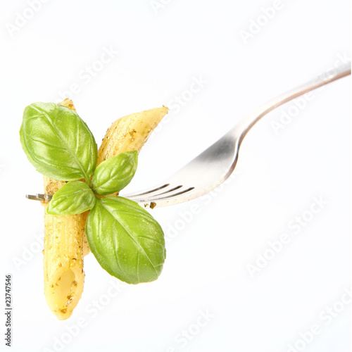 Penne with pesto on a fork decorated with basil