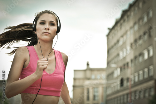 Young person listening misic running in city street