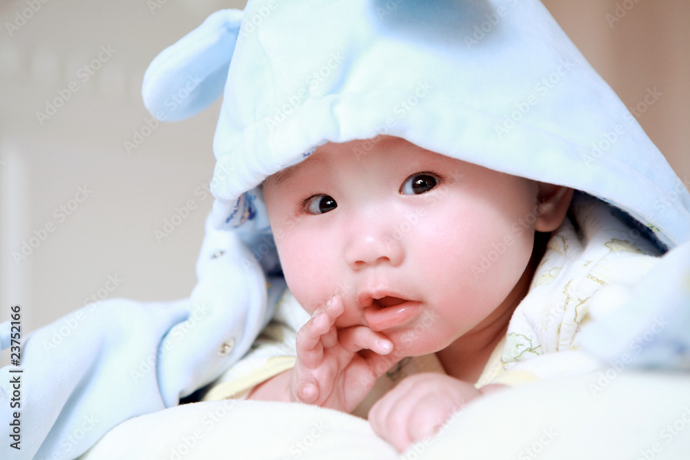 Cute little baby in bed, wearing a blue cartoon clothes Cute little baby in bed, wearing a blue cartoon clothes