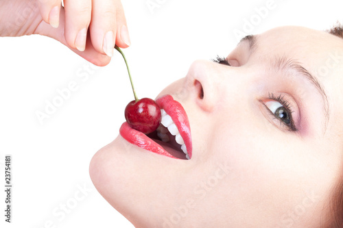 beauty female face with cherry in her mouth isolated on white