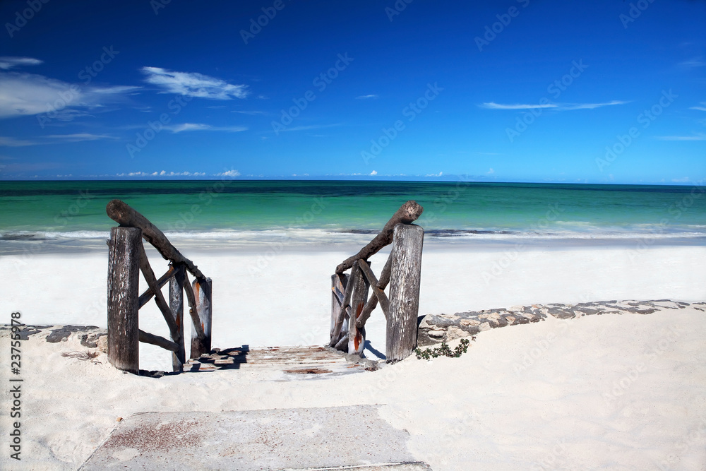 Fototapeta premium Old wooden stairs leading on white sandy beach