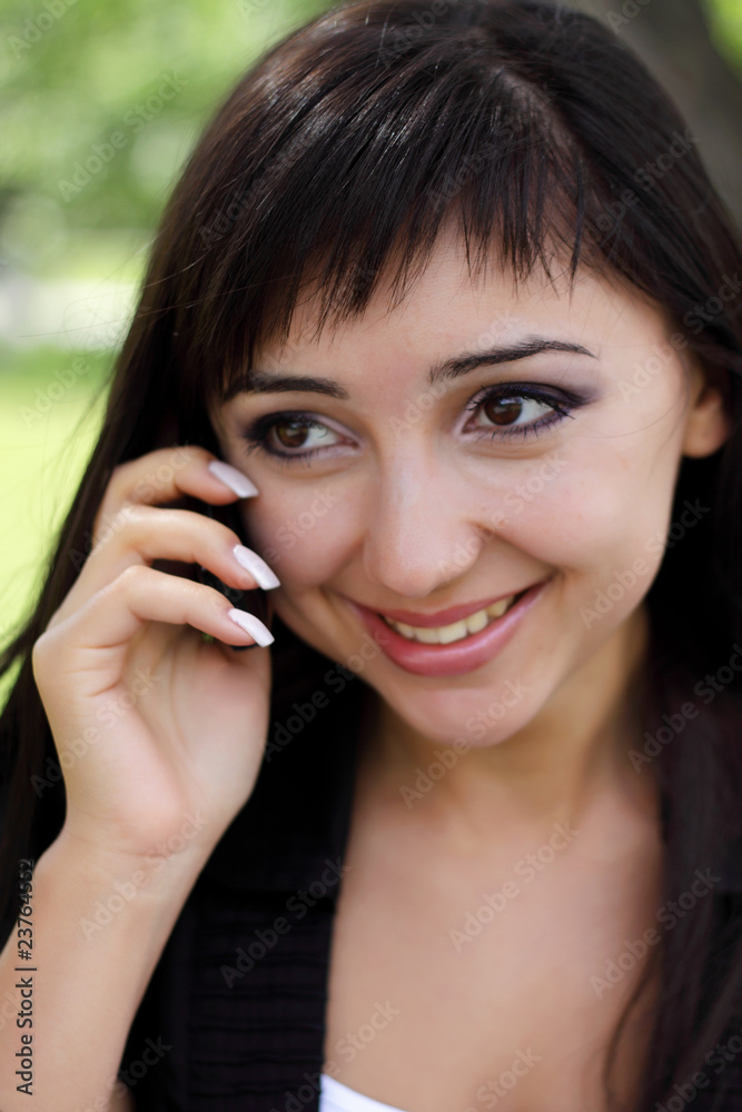 Young woman at spring park talking on the phone. Young woman at spring park talking on the phone.