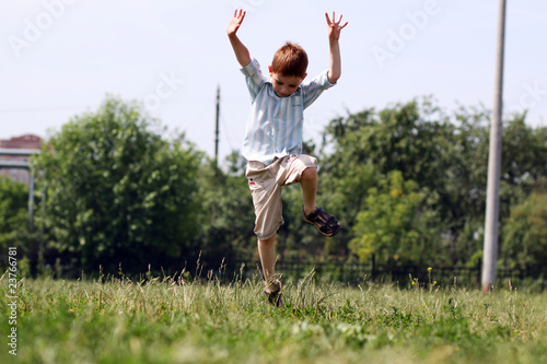 little boy runs in a summer park