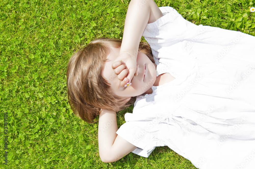 three years old girl resting on grass three years old girl resting on grass