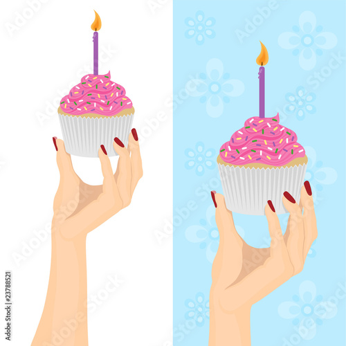 Female hand holding a birthday cupcake.