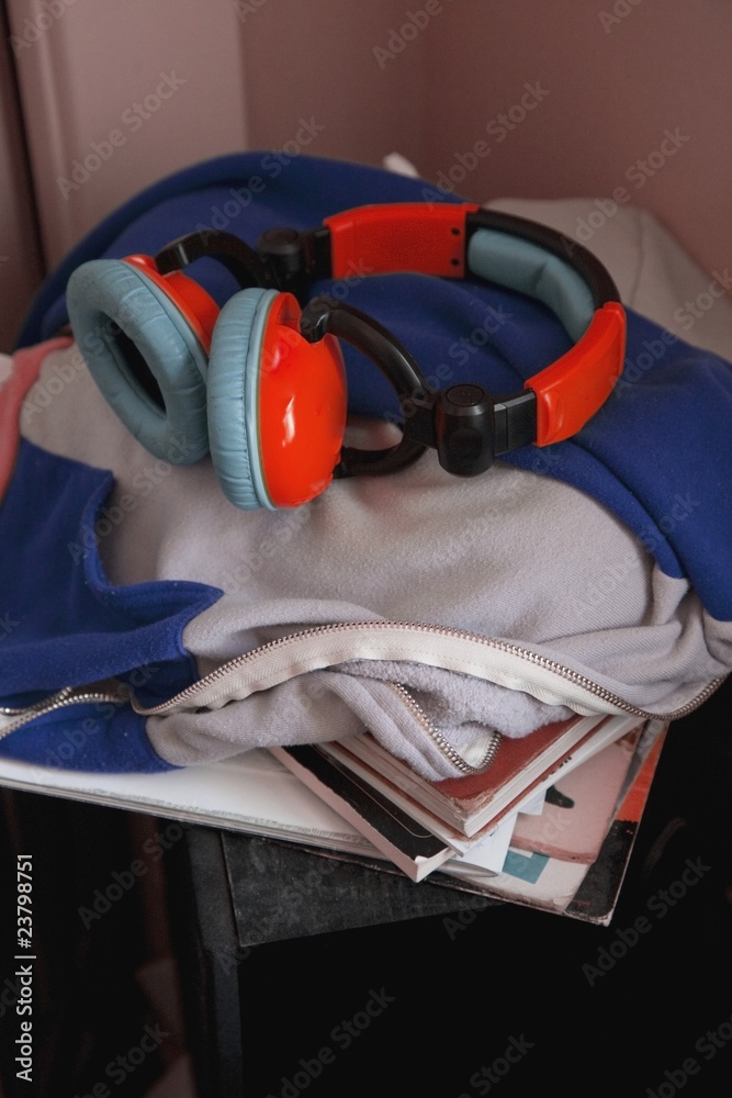 Earphones On Top Of A Pile Of Books And Clothing