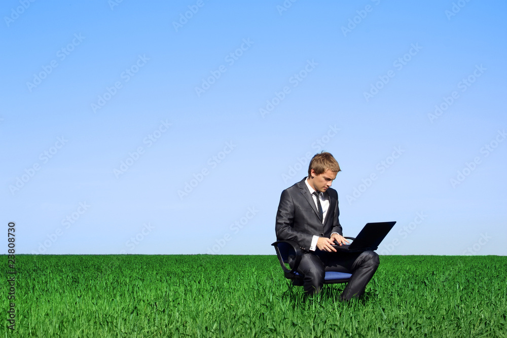 Businessman sitting outdoors with laptop computer Businessman sitting outdoors with laptop computer