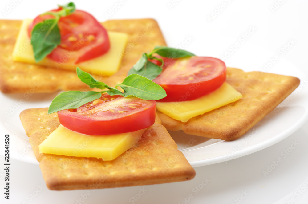 Crackers with cheese, tomato and basil