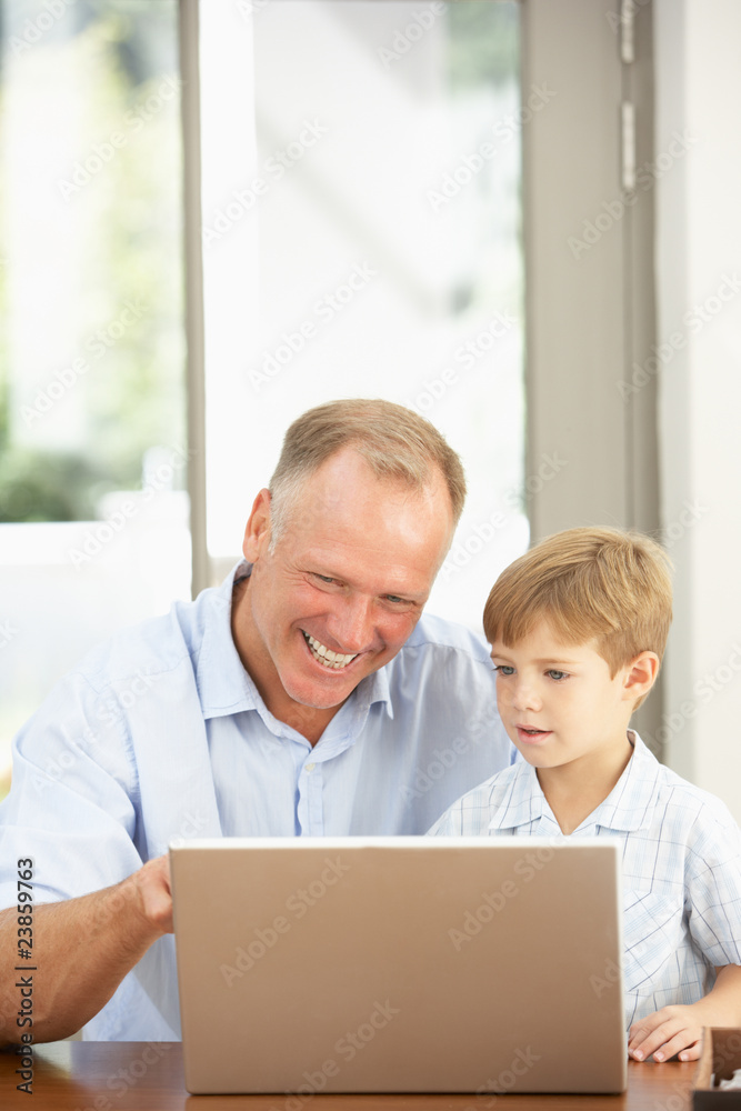 Father And Son Using Laptop At Home