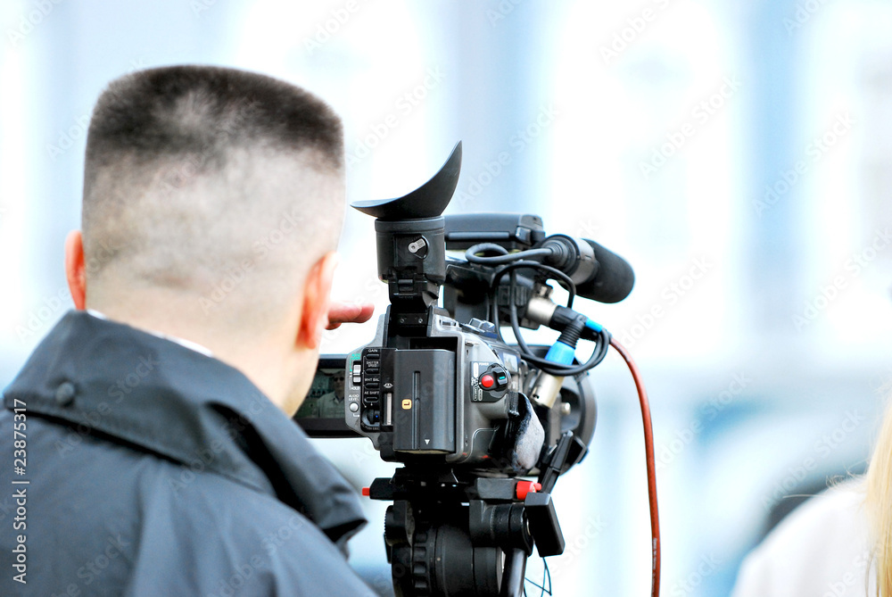 cameraman worcking with camera on a tripod