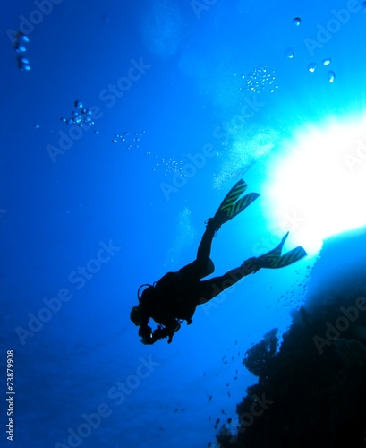 Diver's silhouette over the sun