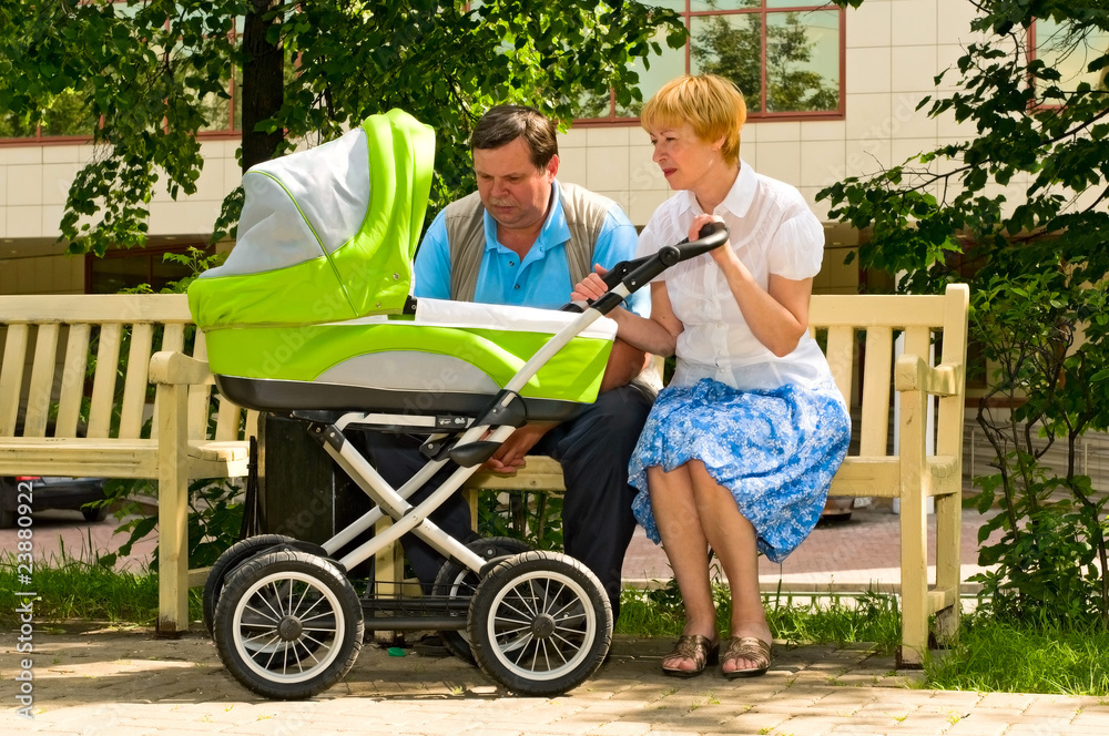 mature couple with baby carriage mature couple with baby carriage