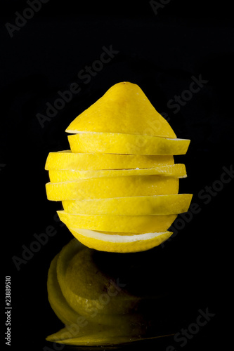 нарезанный лимон на черном фоне с отражением