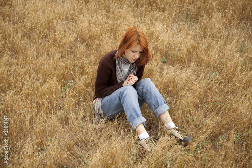 Lonely sad red-haired girl at field © Masson