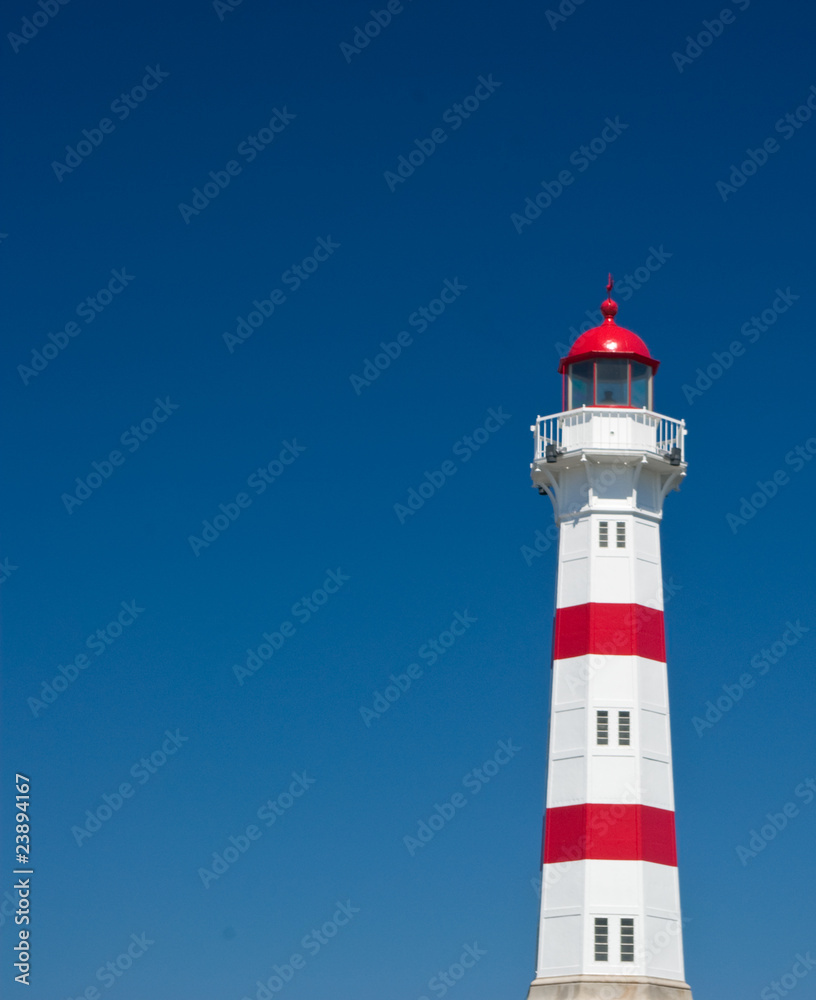red and white lighthouse on blue sky background