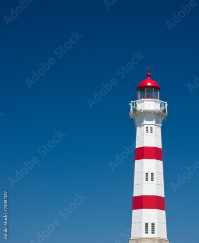 red and white lighthouse on blue sky background