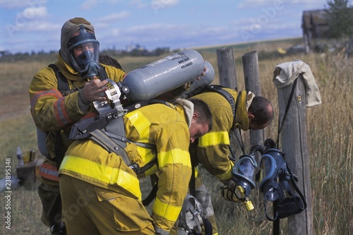Fireman Adjusting Equipment On Partner